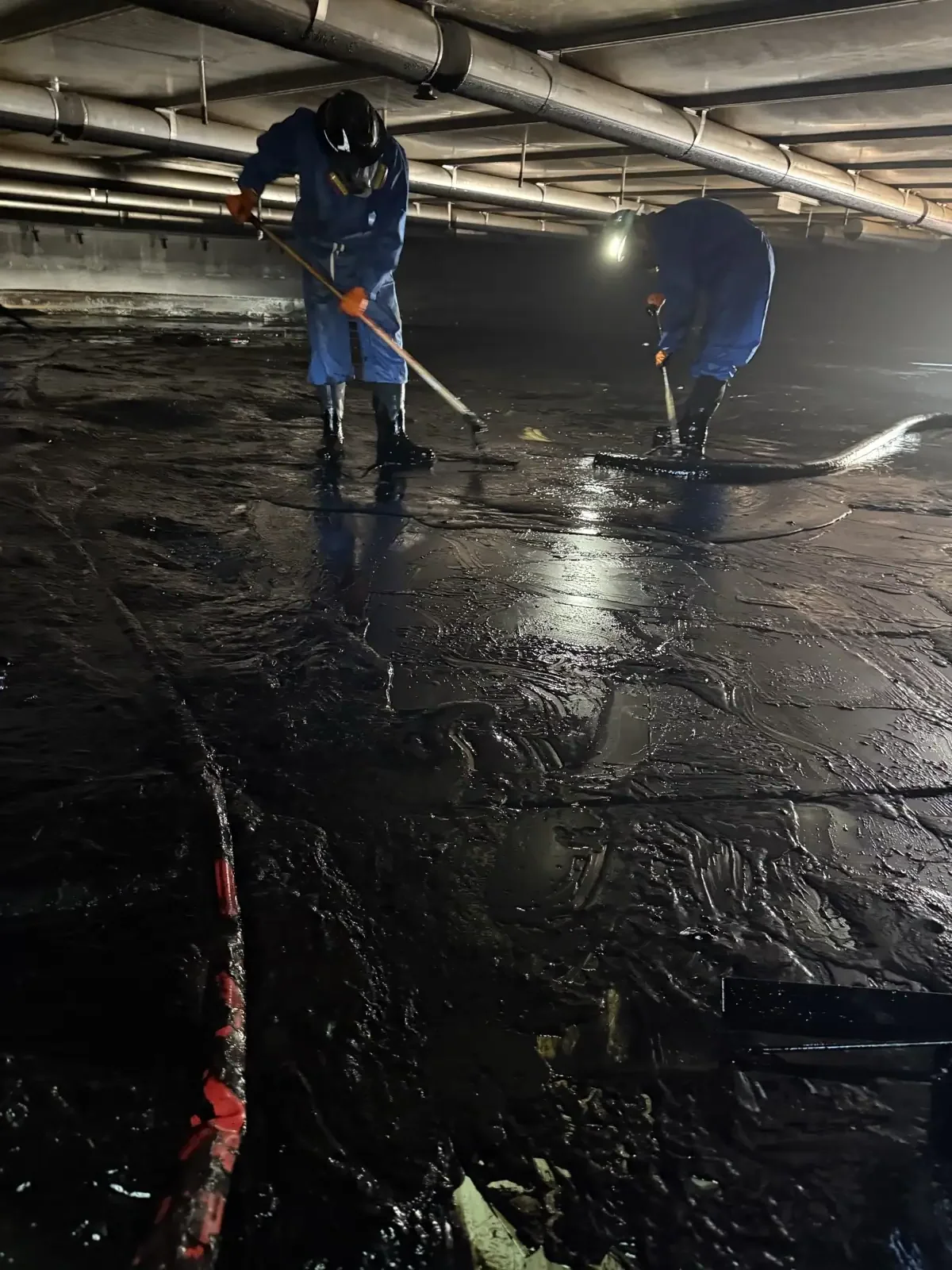 Workers cleaning industrial tank